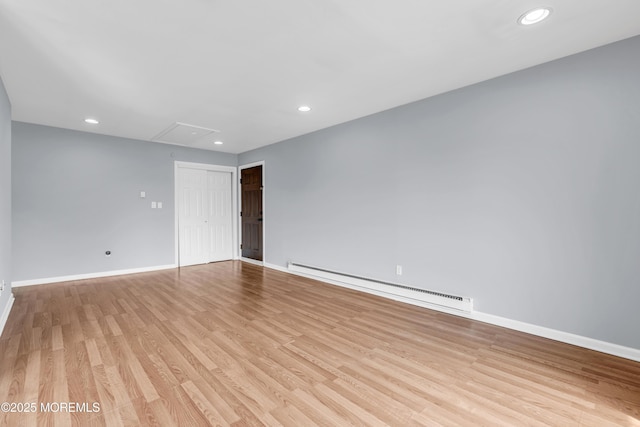 empty room featuring recessed lighting, a baseboard radiator, baseboards, and light wood finished floors