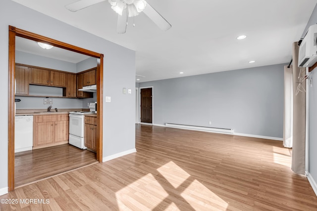 kitchen featuring a baseboard heating unit, under cabinet range hood, light wood-type flooring, light countertops, and white appliances