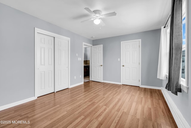 unfurnished bedroom featuring baseboards, light wood finished floors, ceiling fan, a closet, and multiple windows