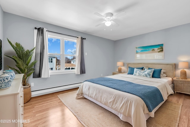 bedroom with baseboard heating, light wood-type flooring, and a ceiling fan