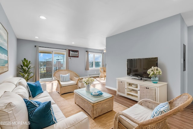 living room featuring a baseboard heating unit, baseboards, a wall unit AC, recessed lighting, and wood finished floors