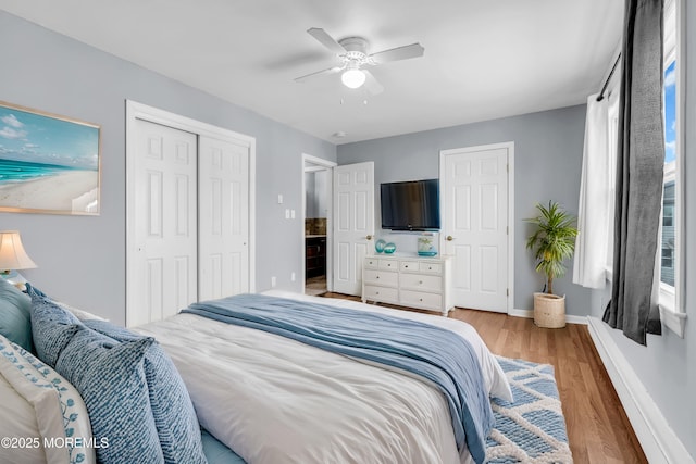 bedroom with light wood-style flooring, a ceiling fan, baseboards, and a closet