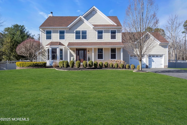 view of front of property with a garage, a front yard, driveway, and fence