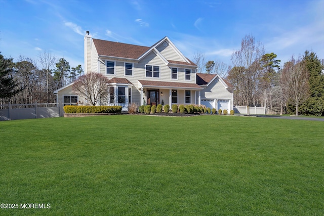 view of front of property with aphalt driveway, fence, a front yard, a garage, and a chimney