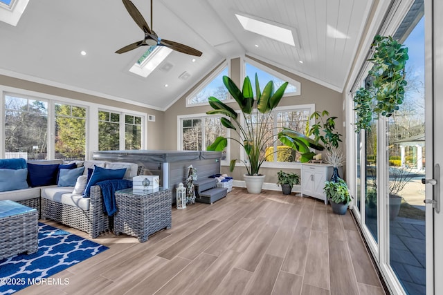 sunroom / solarium featuring lofted ceiling with skylight and a ceiling fan