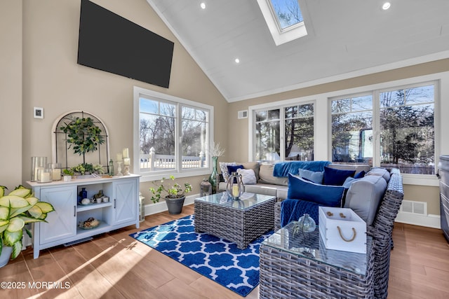 living room featuring visible vents, wood finished floors, a healthy amount of sunlight, and a skylight