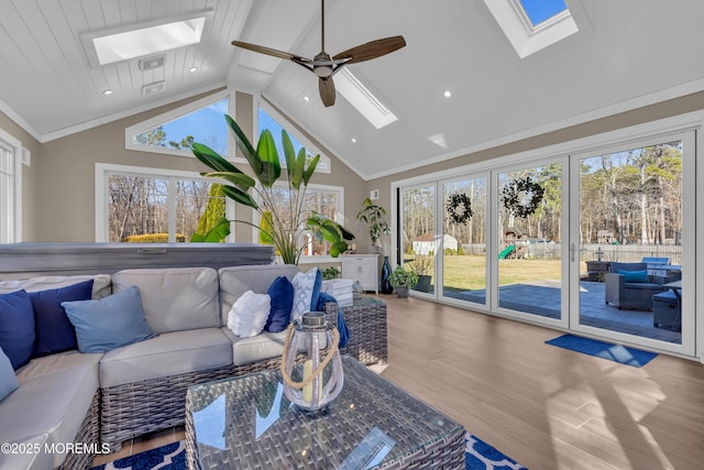 living area with crown molding, a skylight, recessed lighting, and wood finished floors