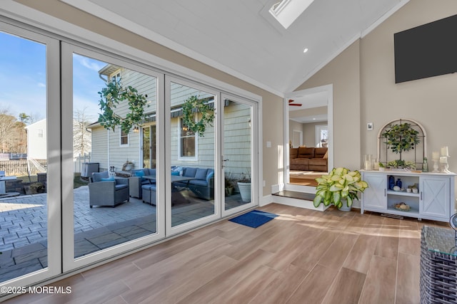 doorway with baseboards, high vaulted ceiling, wood tiled floor, recessed lighting, and crown molding