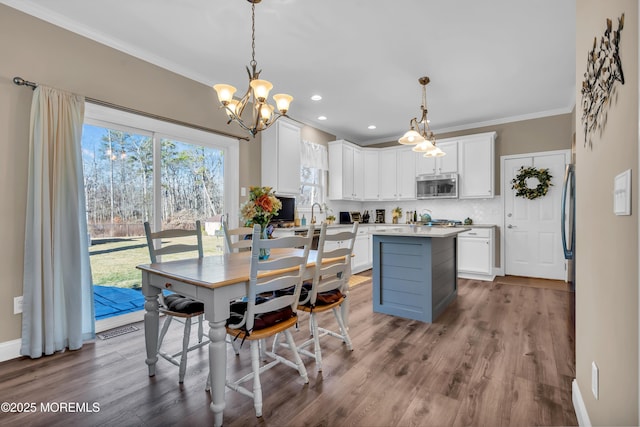 dining space with recessed lighting, wood finished floors, baseboards, and ornamental molding