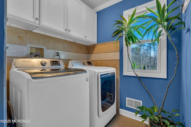 laundry room with tile patterned floors, visible vents, ornamental molding, washer and dryer, and cabinet space