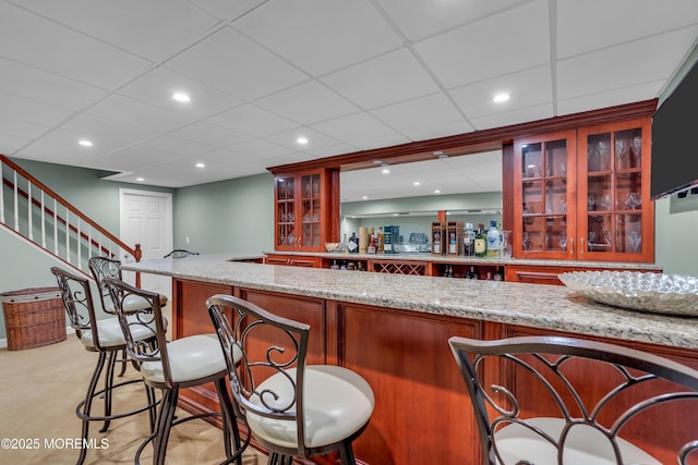 bar with indoor wet bar, stairway, and recessed lighting