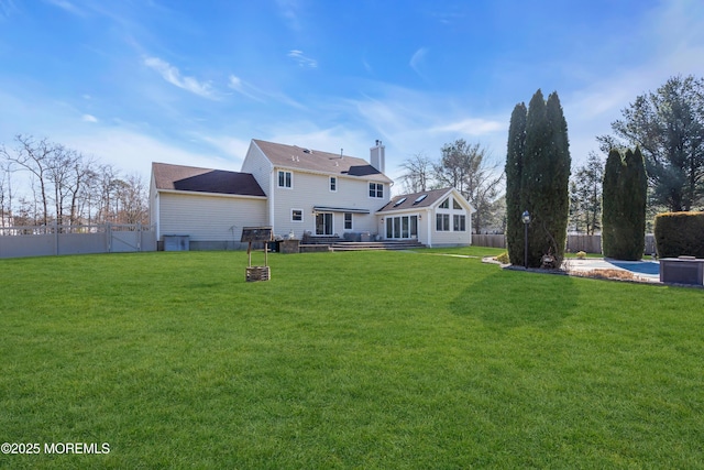 back of house featuring a yard and fence