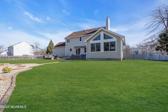 rear view of house featuring a yard, fence private yard, and a chimney