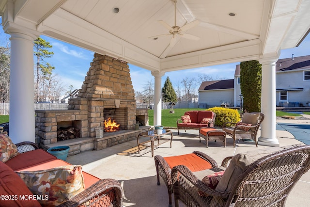 view of patio with an outdoor living space with a fireplace and a ceiling fan