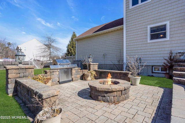 view of patio with an outdoor kitchen, area for grilling, and an outdoor fire pit