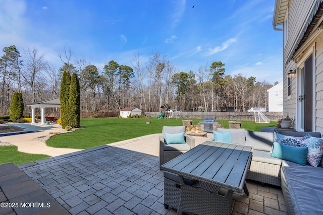 view of patio / terrace featuring a playground, fence, a gazebo, outdoor dining area, and an outdoor structure