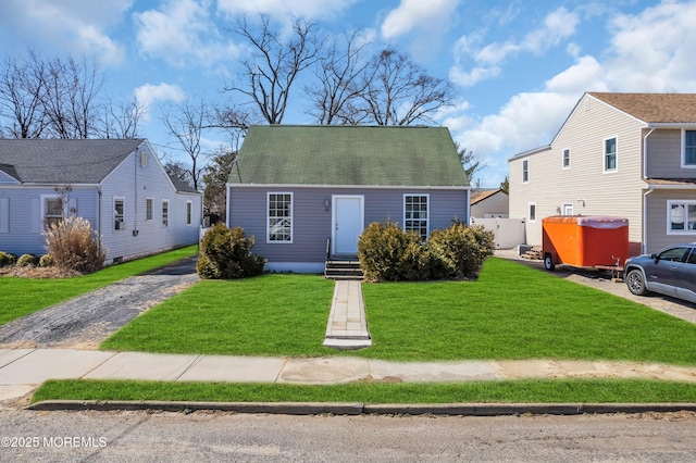 view of front of property featuring entry steps, a front lawn, and fence