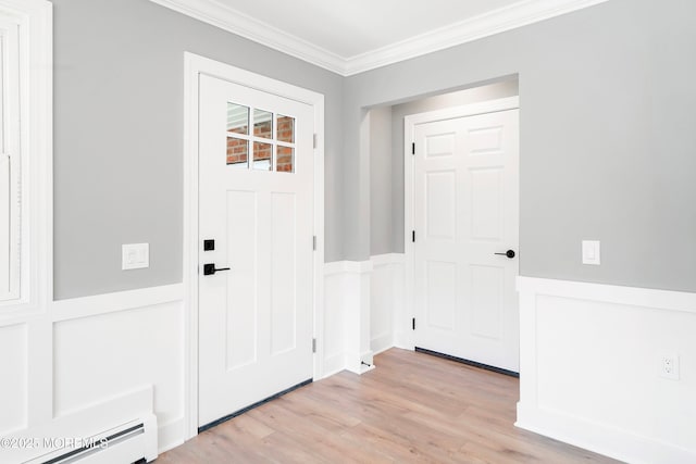 foyer entrance featuring light wood finished floors, baseboard heating, wainscoting, and crown molding