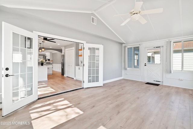 unfurnished sunroom featuring visible vents, a ceiling fan, french doors, arched walkways, and vaulted ceiling