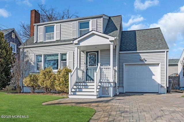 traditional-style home featuring a shingled roof, a front lawn, a garage, and a chimney