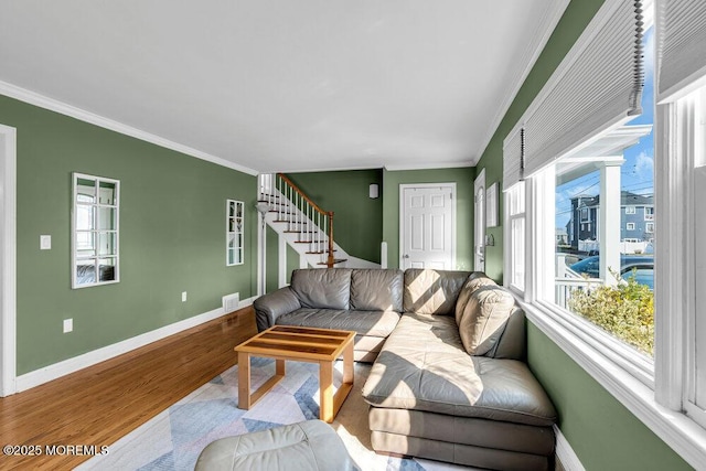 living room with visible vents, baseboards, stairway, ornamental molding, and wood finished floors