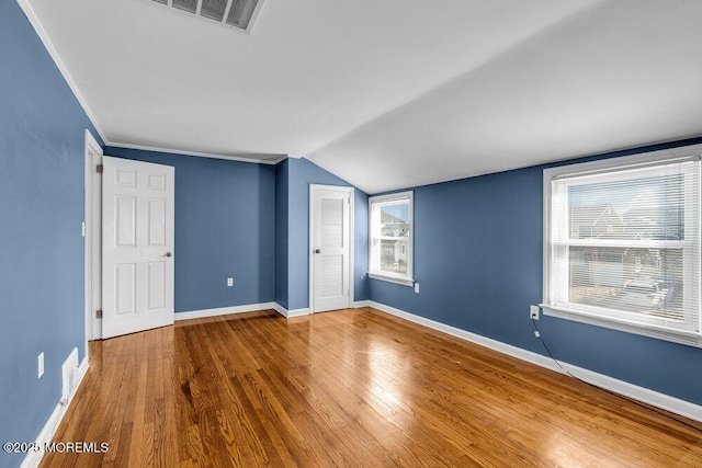 bonus room with visible vents, baseboards, lofted ceiling, and wood finished floors