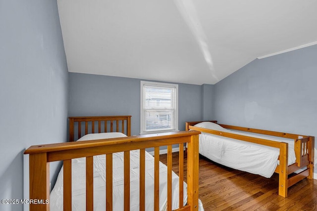 bedroom featuring lofted ceiling and wood finished floors