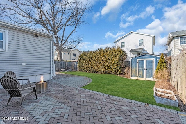 view of patio / terrace featuring a storage shed, a vegetable garden, a fenced backyard, and an outdoor structure