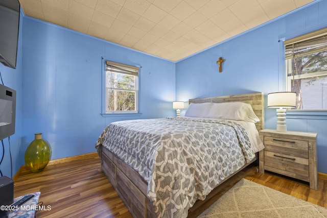 bedroom featuring baseboards and wood finished floors