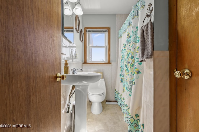 bathroom with a shower with shower curtain, tile patterned floors, and toilet