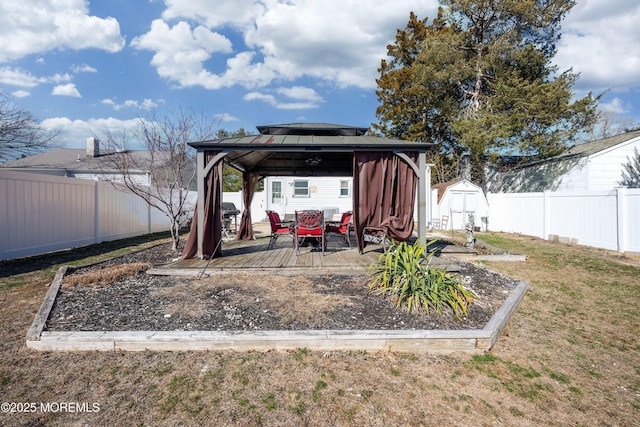 view of patio / terrace with a gazebo, a storage unit, an outbuilding, and a fenced backyard