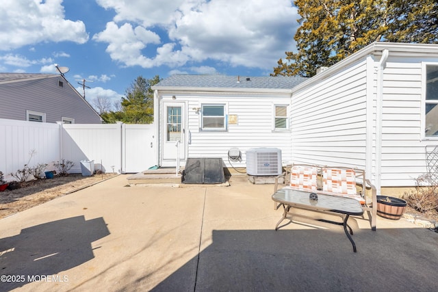 back of house with a patio area, central air condition unit, roof with shingles, and fence