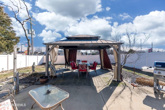 view of patio / terrace with a gazebo, outdoor dining area, a fenced backyard, and a wooden deck