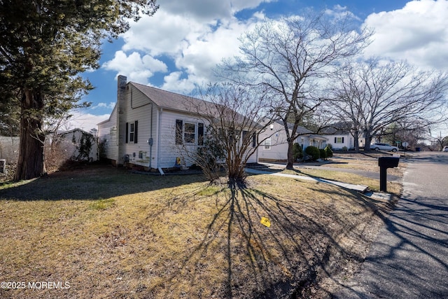 view of front of home featuring a chimney, a front lawn, and fence