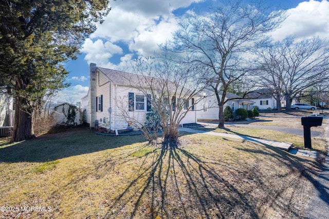 view of front of property featuring a front lawn and a chimney