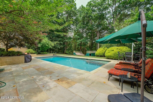 view of pool with a patio area and a pool with connected hot tub