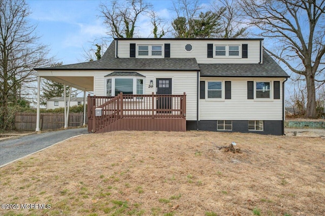 view of front of property with a carport, driveway, a shingled roof, and fence