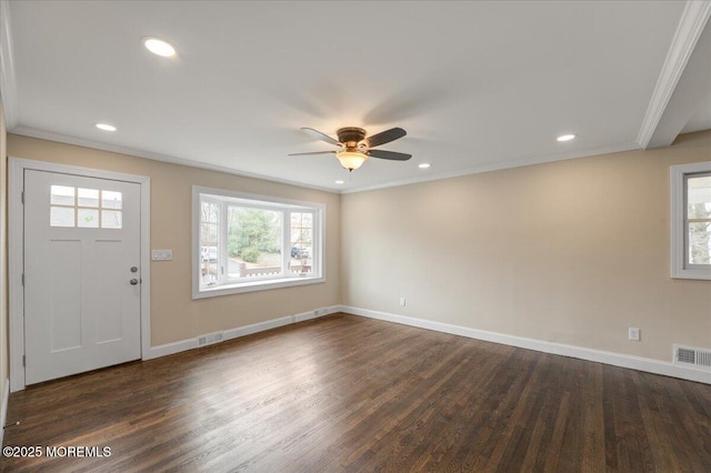 foyer entrance with plenty of natural light, crown molding, and dark wood-style flooring