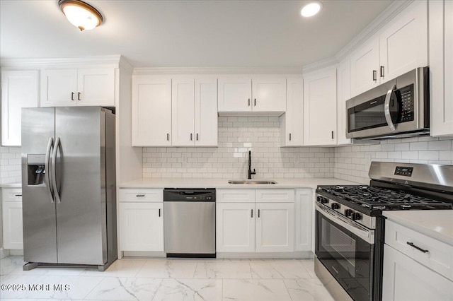 kitchen featuring marble finish floor, a sink, white cabinetry, appliances with stainless steel finishes, and light countertops