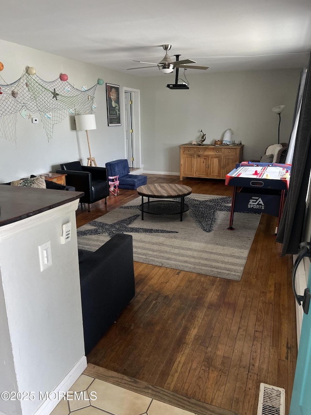 living room with hardwood / wood-style floors, visible vents, and ceiling fan