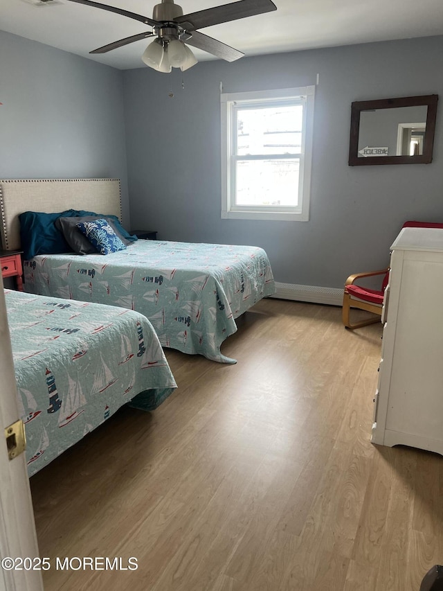 bedroom featuring visible vents, a ceiling fan, baseboards, and light wood finished floors