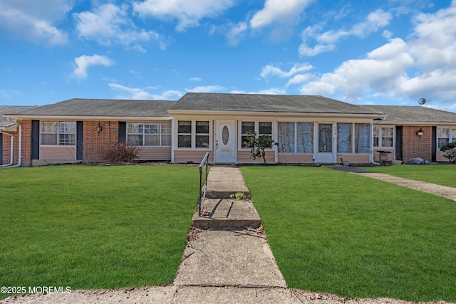 ranch-style house featuring a front yard and brick siding