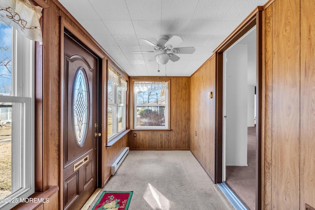 unfurnished sunroom featuring a ceiling fan and a baseboard radiator