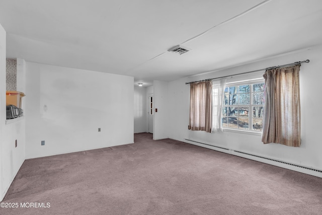 empty room with a baseboard heating unit, visible vents, and carpet flooring