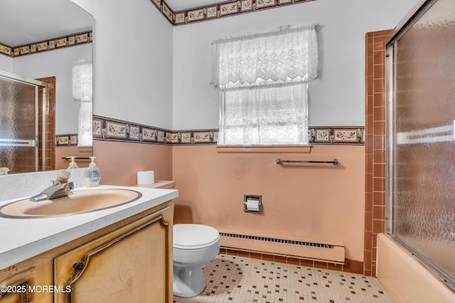 full bath featuring vanity, enclosed tub / shower combo, a baseboard radiator, tile patterned floors, and toilet