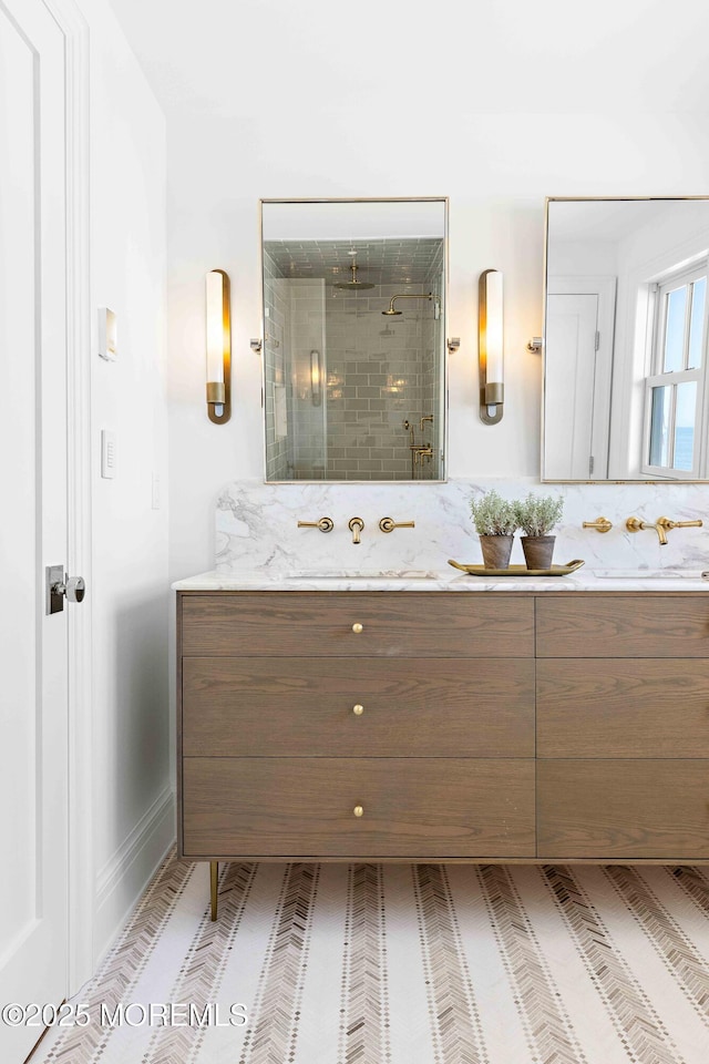 full bath with double vanity, a shower stall, and a sink