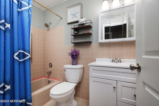 bathroom featuring a wainscoted wall, toilet, vanity, shower / bath combination with curtain, and tile walls