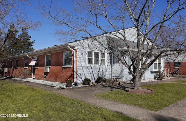 view of front of home featuring brick siding and a front lawn