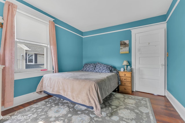 bedroom with wood finished floors and baseboards