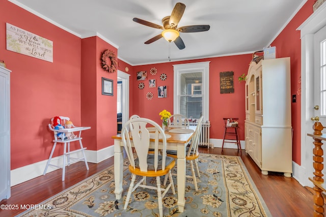 dining room featuring crown molding, wood finished floors, baseboards, and ceiling fan